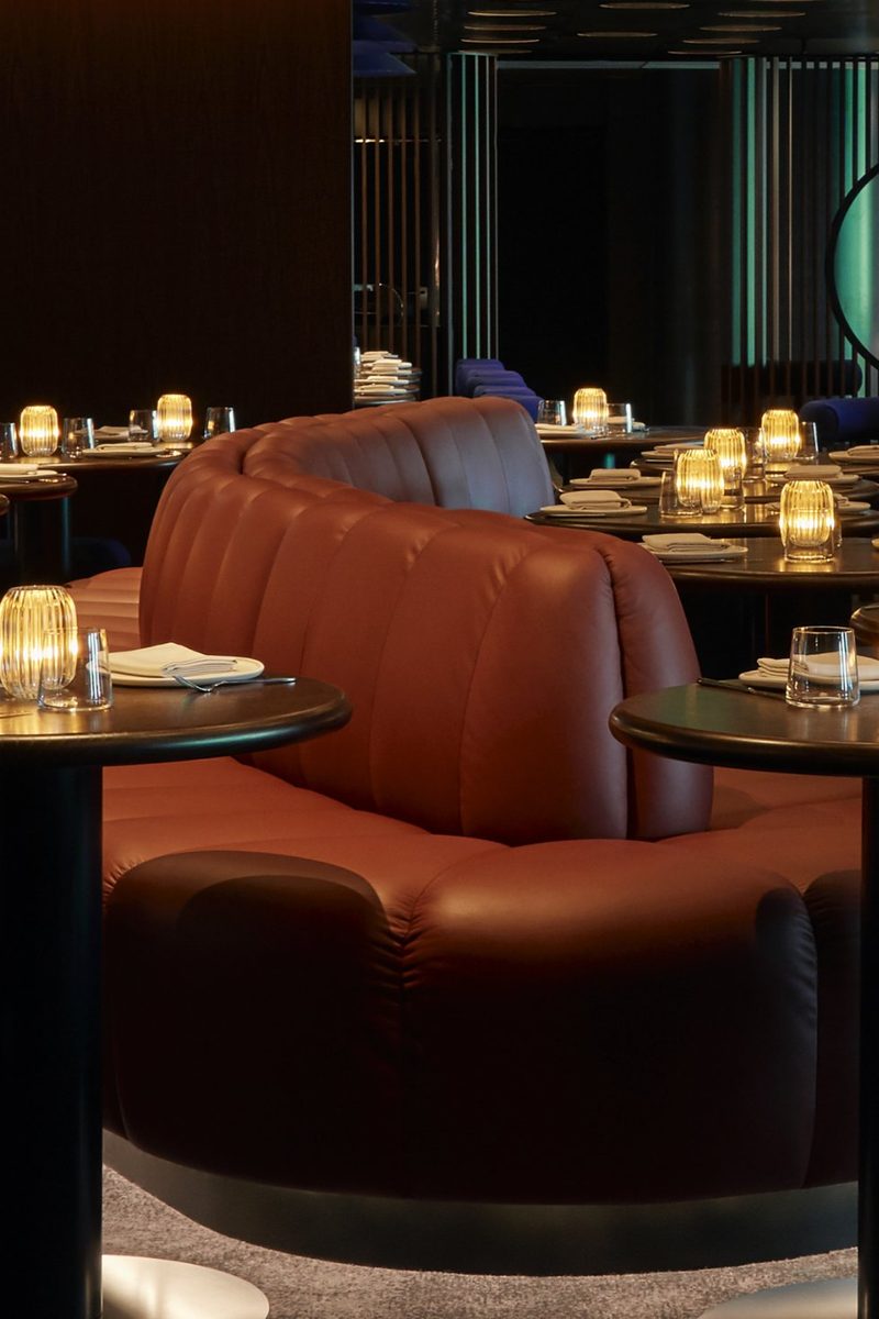 Curved leather seating and candlelit dining tables inside Pink Agave.